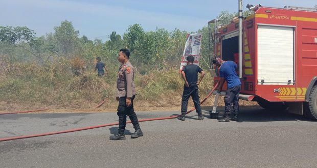 Polsek Mentok Sigap Bantu Padamkan Api Kebakaran Lahan kosong di Pinggir Jalan Raya peltim Lapangan Golf Desa Belo laut Kec. Mentok Kab. Bangka barat.